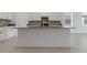 Kitchen island with stainless steel sink and gray countertop, complemented by white cabinets at 1908 Blissful Dr, Kissimmee, FL 34744