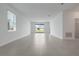 Open living room with gray tile flooring, bright white walls, and sliding glass doors to the backyard at 1908 Blissful Dr, Kissimmee, FL 34744
