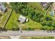 Aerial view features a property with outbuildings along a roadside, surrounded by trees and lawns at 1981 N County Road 426, Oviedo, FL 32765