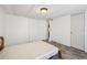 Bedroom with wood-look flooring, plain bed frame, and two doors at 1981 N County Road 426, Oviedo, FL 32765