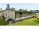 A side angle view of a light colored house with green grass at 1981 N County Road 426, Oviedo, FL 32765