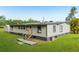 Home exterior displaying a side view, small porch, and green lawn at 1981 N County Road 426, Oviedo, FL 32765