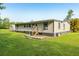 Home exterior displaying a side view, small porch, and green lawn at 1981 N County Road 426, Oviedo, FL 32765