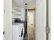Convenient laundry room featuring a washer, dryer, and shelving for storage at 1981 N County Road 426, Oviedo, FL 32765