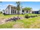 Exterior view of backyard featuring lawn, trees, covered patio, and lanai at 2026 Key Bay Trl, Kissimmee, FL 34747
