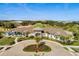 An aerial view of the clubhouse and circular driveway, surrounded by lush landscaping and palm trees at 2026 Key Bay Trl, Kissimmee, FL 34747