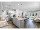 Open-concept kitchen featuring stainless appliances, white cabinets, an island with barstool seating at 2026 Key Bay Trl, Kissimmee, FL 34747