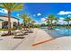 A luxurious pool area with ample seating and beautiful palm trees, perfect for relaxation and entertainment at 2026 Key Bay Trl, Kissimmee, FL 34747