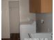 Functional laundry room with a washing machine, sink, and storage shelves behind a door at 21708 Royal St Georges Ln, Leesburg, FL 34748