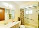 Bathroom with tiled tub/shower, window, vanity, and green accents at 2729 Hilda Ct, Orlando, FL 32826