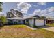 Charming single-story home featuring a two-car garage, blue trim, and well-maintained landscaping at 2729 Hilda Ct, Orlando, FL 32826