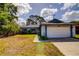 Charming single-story home featuring a two-car garage, blue trim, and well-maintained landscaping at 2729 Hilda Ct, Orlando, FL 32826