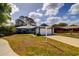Charming single-story home featuring a two-car garage, blue trim, and well-maintained landscaping at 2729 Hilda Ct, Orlando, FL 32826