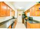 Well-lit kitchen featuring dark countertops, wood cabinets, and modern appliances at 2729 Hilda Ct, Orlando, FL 32826