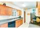 Well-lit kitchen with dark countertops, wood cabinets, and black appliances at 2729 Hilda Ct, Orlando, FL 32826