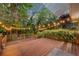 Backyard wooden deck and string lights with lush foliage and landscaping at 275 W 4Th St, Chuluota, FL 32766
