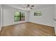 Sunny bedroom with wood floors and view of the lush backyard through the black-framed windows at 275 W 4Th St, Chuluota, FL 32766