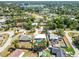 An aerial view of a suburban neighborhood with houses, pools, green trees, and a lake in the distance at 2990 Mallard Dr, Deltona, FL 32738