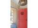 A lovely home entryway features a bright red door with welcome emblem and stylish overhead lighting at 2990 Mallard Dr, Deltona, FL 32738