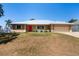 Charming single-story home features a silver metal roof, manicured lawn and a bright red front door at 2990 Mallard Dr, Deltona, FL 32738