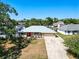 Aerial view of the home's exterior, displaying its metal roof, red door and well-kept lawn at 2990 Mallard Dr, Deltona, FL 32738