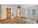 Open living room with modern ceiling fan, wood-look floors, and stylish barn door to bathroom at 2990 Mallard Dr, Deltona, FL 32738
