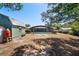 Backyard view of the pool, shed, and firepit, framed by lush greenery and blue skies at 2990 Mallard Dr, Deltona, FL 32738