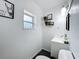 Small bathroom features natural light with a pedestal sink and a decorative mirror at 3019 Page Ave, Orlando, FL 32806