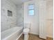 Bright bathroom with a tiled shower over tub and new toilet at 3019 Page Ave, Orlando, FL 32806