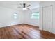 Bright bedroom featuring wood floors, a ceiling fan, and closet with updated windows allowing natural light at 3019 Page Ave, Orlando, FL 32806
