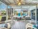 A screened-in lanai leads to the outdoor pool featuring cushioned seating, overhead fan and exterior view at 3019 Page Ave, Orlando, FL 32806