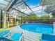 Enclosed pool featuring a refreshing pool with lounge chairs for relaxing and enjoying the outdoors at 3019 Page Ave, Orlando, FL 32806