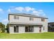 Home's back exterior showcasing large windows, stucco walls, and a well-maintained lawn at 346 Willet Ave, Apopka, FL 32703