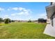 Large grassy backyard with mature trees, adjacent to a house with a screened-in porch, all under a blue sky at 346 Willet Ave, Apopka, FL 32703