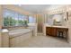 Large bathroom featuring soaking tub, glass shower, vanity with seating, and window at 346 Willet Ave, Apopka, FL 32703
