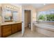 Bathroom with double vanity, soaking tub, window, and toilet behind open door at 346 Willet Ave, Apopka, FL 32703