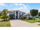 Exterior shot of a large two-story home featuring gray stucco, white trim, and a well-maintained lawn at 346 Willet Ave, Apopka, FL 32703