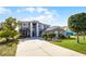 View of a two-story home with a well-manicured lawn, landscaped yard, and a gray stucco exterior at 346 Willet Ave, Apopka, FL 32703