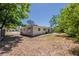 Wide backyard with lush green space, partially fenced with beige home exterior, and gray patio at 3718 Mitchell Rd, Orlando, FL 32808