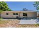 Home exterior featuring sliding glass doors to the backyard, a gray patio, and ample green space at 3718 Mitchell Rd, Orlando, FL 32808