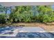 Expansive backyard featuring a gray patio with lush greenery and natural shade, perfect for outdoor relaxation at 3718 Mitchell Rd, Orlando, FL 32808
