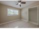 Neutral bedroom features tile flooring, a ceiling fan, a window, and a closet at 3718 Mitchell Rd, Orlando, FL 32808