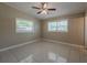 Bedroom boasts tile floors, ceiling fan, and dual windows to the exterior at 3718 Mitchell Rd, Orlando, FL 32808