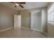 Clean bedroom features tile flooring, a ceiling fan, closet, and exterior window at 3718 Mitchell Rd, Orlando, FL 32808