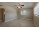 Well-lit bedroom featuring tile floors, ceiling fan, and two windows for natural light at 3718 Mitchell Rd, Orlando, FL 32808