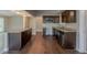 Spacious kitchen featuring dark wood cabinets, granite countertops, stainless steel appliances, and wood-look tile floors at 3718 Mitchell Rd, Orlando, FL 32808