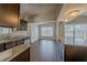 Kitchen and dining area featuring granite counters, stainless appliances, dark wood cabinets, and wood-look tile floors at 3718 Mitchell Rd, Orlando, FL 32808