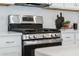 A stainless steel gas range sits below a vent hood in the modern kitchen at 426 Belmond Dr, Debary, FL 32713