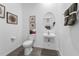Compact powder room with a pedestal sink, toilet, and minimalist decor at 426 Belmond Dr, Debary, FL 32713