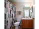 Cozy bathroom with patterned shower curtain, wood vanity, and tiled floor at 443 S Observatory Dr, Orlando, FL 32835